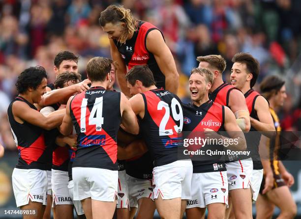 Anthony McDonald-Tipungwuti of the Bombers is congratulated by team mates after kicking a goal during the round one AFL match between Hawthorn Hawks...