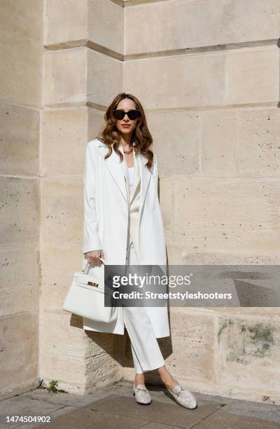 Alexandra Lapp is seen wearing COMMA coat in white, COMMA long vest in white, COMMA top in white, COMMA pants in white, HERMES Kelly bag in white,...