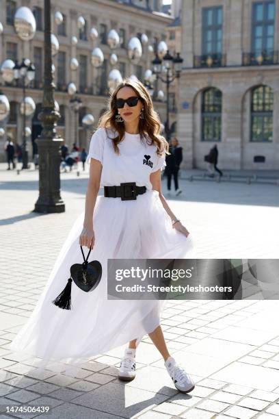 Alexandra Lapp is seen wearing AMI PARIS t-shirt, DOLCE&GABBANA belt in black, tull skirt in white, CHANEL logo ear rings in silver, CELINE...