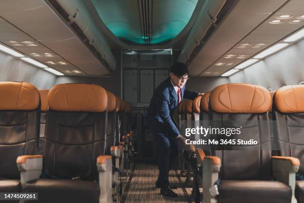 steward takes care of the tourists on the plane - hostess foto e immagini stock