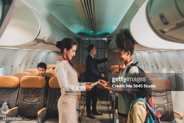 air steward takes care of passengers on the plane. - air stewardess foto e immagini stock