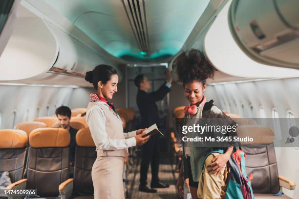 air steward takes care of passengers on the plane. - first class plane stock-fotos und bilder