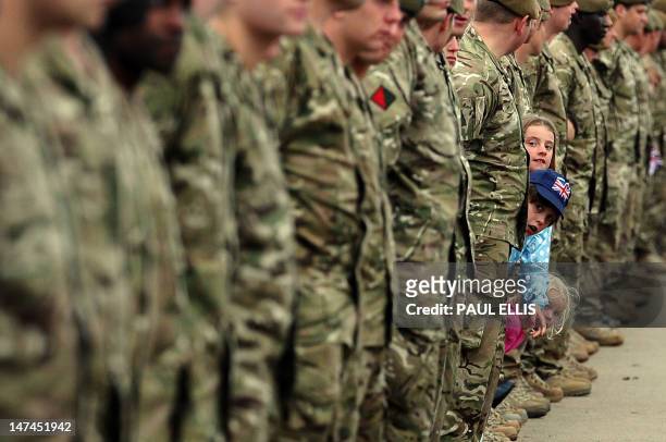 Children wait for decorated Lance Corporal Johnson Beharry to carry the Olympic the flame past the National Armed Services Memorial to mark Armed...
