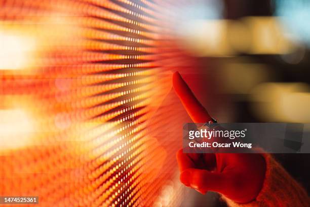 close-up of woman's hand touching illuminated illuminated digital display - big data people stockfoto's en -beelden