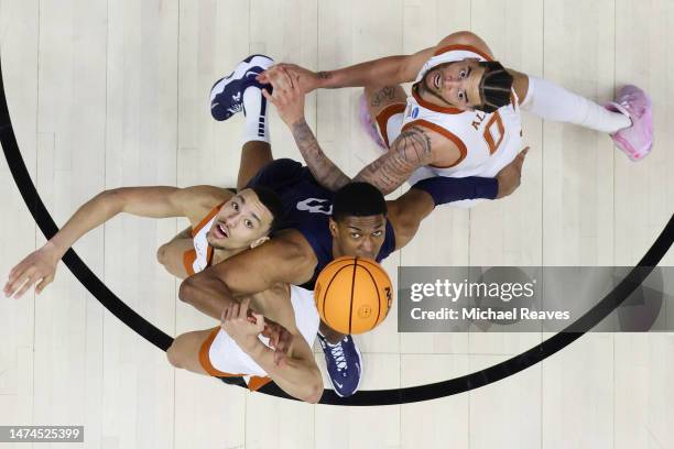 Dylan Disu and Timmy Allen of the Texas Longhorns battle for a rebound with Kebba Njie of the Penn State Nittany Lions in the second round of the...