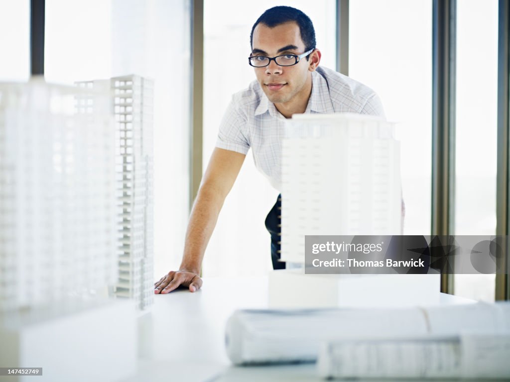 Architect standing at table with models