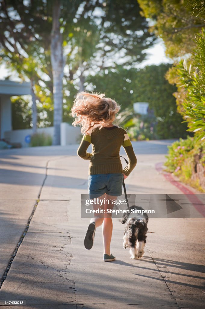 Young woman running her dog