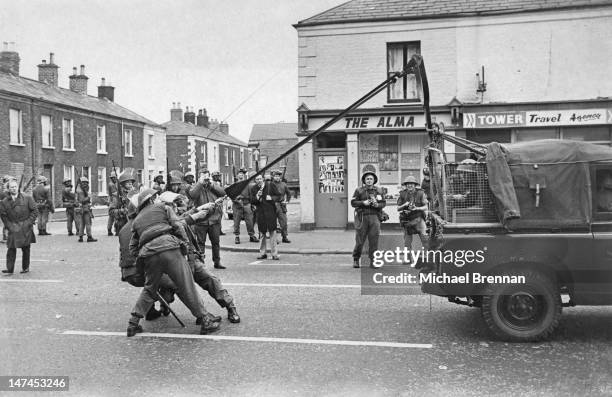 Soldiers of the British Army try out an experimental catapult tear-gas launcher on the Falls Road in Belfast, 1970.