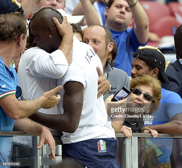 Mario Balotelli of Italy greets family members as his adoptive mother Silvia Balotelli looks during the UEFA EURO 2012 semi final match between...