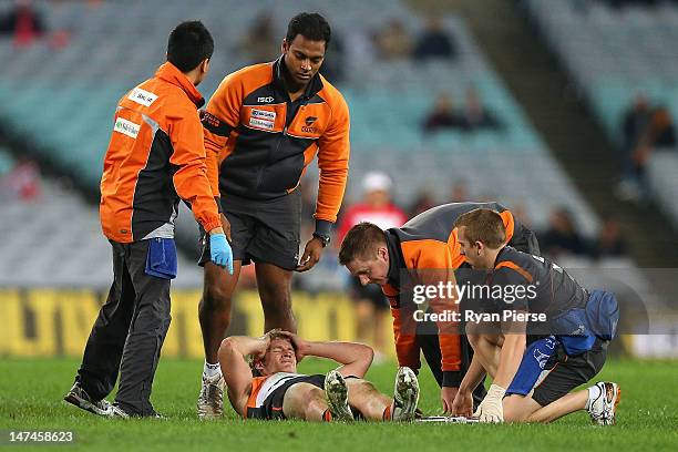 Luke Power of the Giants is injured during the round 14 AFL match between the Sydney Swans and the Greater Western Sydney Giants at ANZ Stadium on...