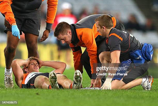 Luke Power of the Giants is injured during the round 14 AFL match between the Sydney Swans and the Greater Western Sydney Giants at ANZ Stadium on...