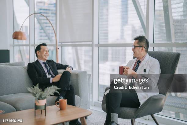 asian chinese male doctor discussion with hospital administrator senior management in hospital lounge - two doctors talking stockfoto's en -beelden