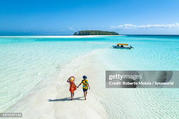 overhead view of man and woman holding hands on idyllic beach - tropische hitte stockfoto's en -beelden