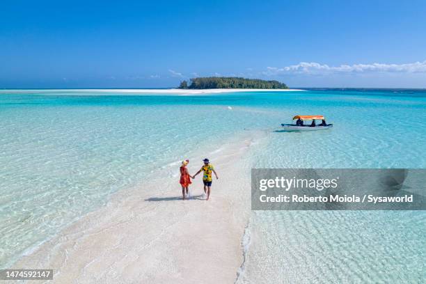 aerial view of couple walking hand in hand in the exotic lagoon - flitterwochen stock-fotos und bilder