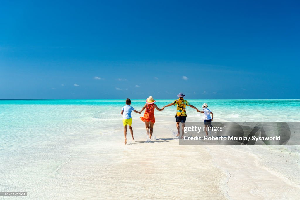Happy family enjoying running in the crystal sea