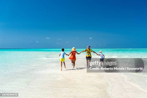 happy family enjoying running in the crystal sea - zanzibar 個照片及圖片檔