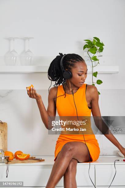 beautiful black girl with headphones, enjoying music from the smart phone - mp3 juices 個照片及圖片檔