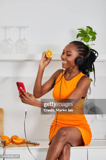 beautiful black girl with headphones, enjoying music from the smart phone - mp3 juices stock pictures, royalty-free photos & images