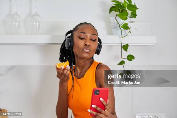 hermosa chica negra con auriculares, disfrutando de la música del teléfono inteligente - mp3 juices fotografías e imágenes de stock