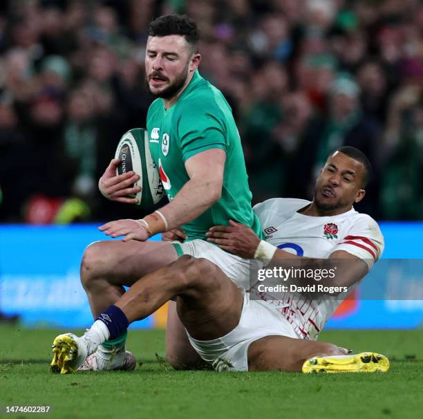 Robbie Henshaw of Ireland is held by Anthony Watson during the Six Nations Rugby match between Ireland and England at Aviva Stadium on March 18, 2023...