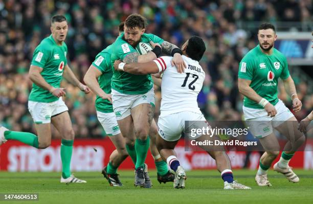 Andrew Porter of Ireland is held by Manu Tuilagi during the Six Nations Rugby match between Ireland and England at Aviva Stadium on March 18, 2023 in...