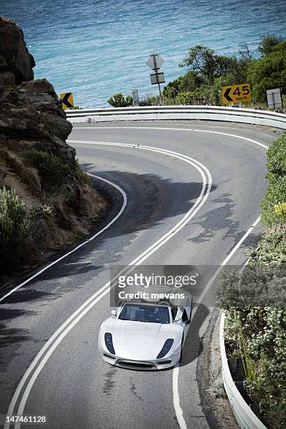 deportes coche en una carretera costera - mercedes fotografías e imágenes de stock