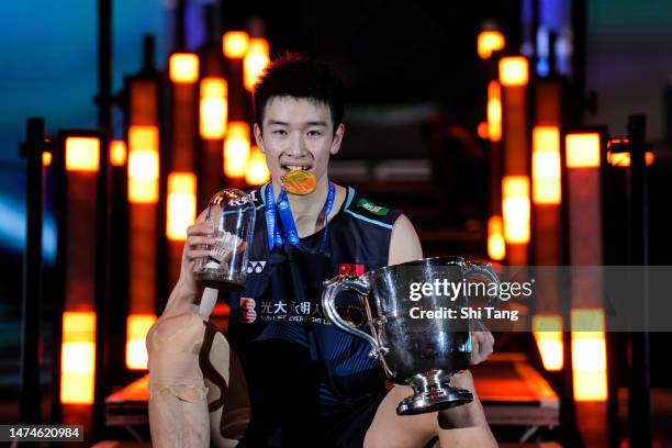 Li Shifeng of China poses with his trophy on the podium after the Men's Single Final match against Shi Yuqi of China on day six of the Yonex All...