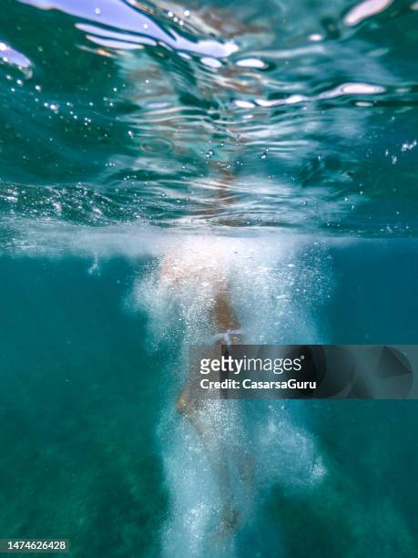 woman jumping in the water - woman diving underwater stock pictures, royalty-free photos & images