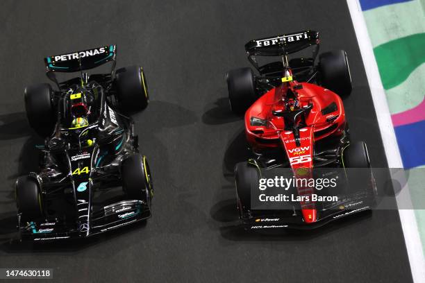 Carlos Sainz of Spain driving the Ferrari SF-23 and Lewis Hamilton of Great Britain driving the Mercedes AMG Petronas F1 Team W14 battle for track...