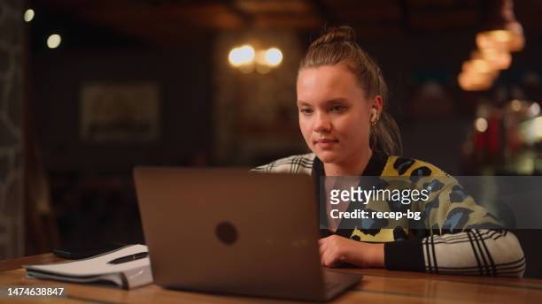 young woman making online video call on laptop in cafe - interview preparation stock pictures, royalty-free photos & images