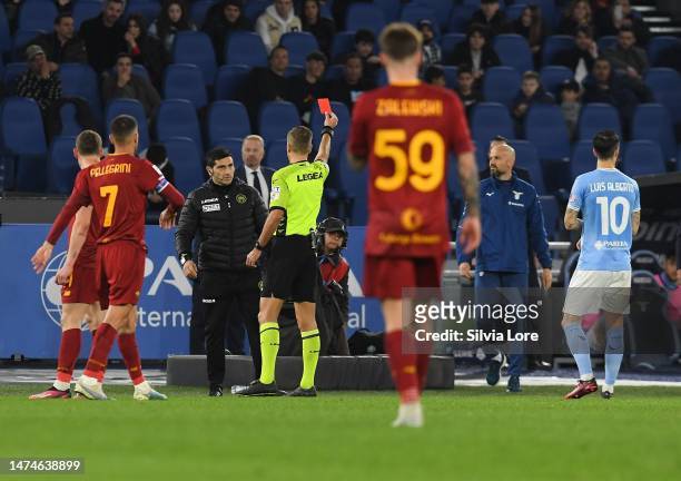 The referee Davide Massa shows a red card during the Serie A match between SS Lazio and AS Roma at Stadio Olimpico on March 19, 2023 in Rome, Italy.