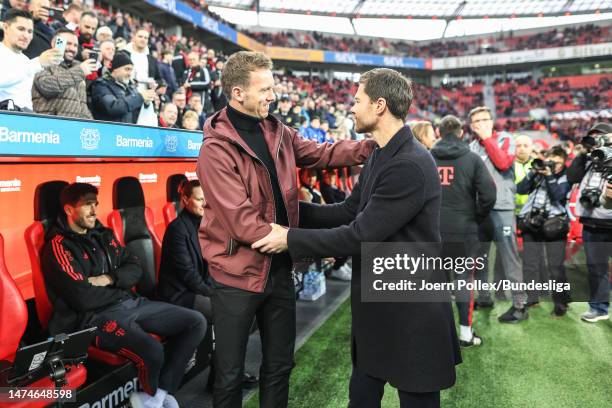 Head coach Xabier Alonso of Leverkusen and head coach Julian Nagelsmann of München chat before the Bundesliga match between Bayer 04 Leverkusen and...