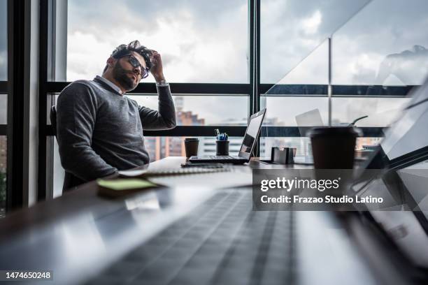 mid adult businessman thinking of something in the office - project failure stock pictures, royalty-free photos & images