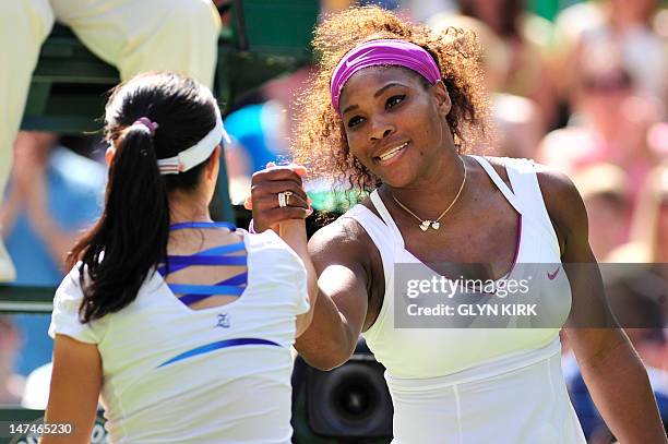 Player Serena Williams shakes hands with China's Zheng Jie after her third round women's singles victory on day six of the 2012 Wimbledon...