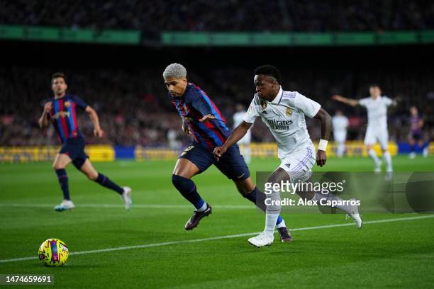 Vinicius Junior of Real Madrid battles for possession with Ronald Araujo of FC Barcelona during the LaLiga Santander match between FC Barcelona and...