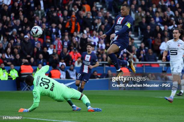 Kylian Mbappe of Paris Saint-Germain shoot is stopped by Stade Rennais goalie Steve Mandanda during the Ligue 1 match between Paris Saint-Germain and...