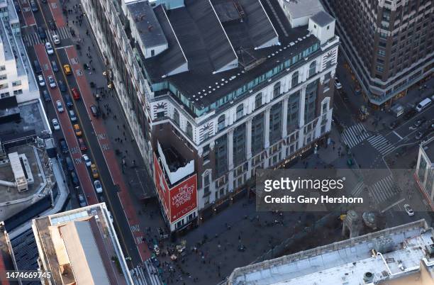 People walk through Herald Square as cars travel on 34th Street in front of Macy's department store as seen from the 86th floor observation deck of...
