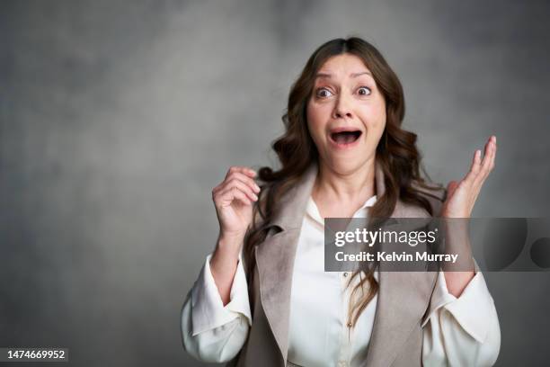 portrait of surprised mature woman - good news bad news stock pictures, royalty-free photos & images