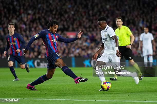 Vinicius Junior of Real Madrid runs with the ball whilst under pressure from Jules Kounde of FC Barcelona during the LaLiga Santander match between...