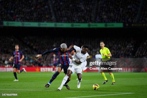 Vinicius Junior of Real Madrid battles for possession with Ronald Araujo of FC Barcelona during the LaLiga Santander match between FC Barcelona and...