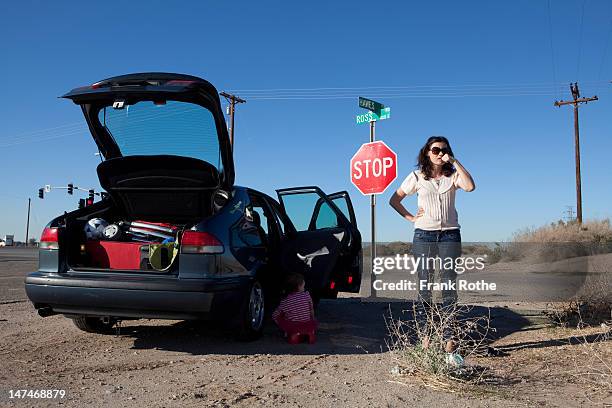 woman stands on a american crossrad with here car - photonica stock pictures, royalty-free photos & images