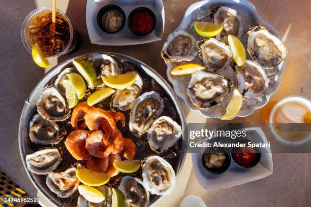 seafood platter with oysters and shrimps, directly above view - beer luxury stock-fotos und bilder