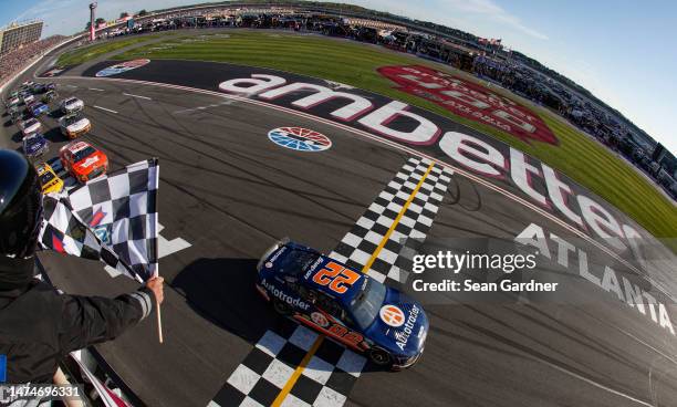 Joey Logano, driver of the Autotrader Ford, takes the checkered flag to win the NASCAR Cup Series Ambetter Health 400 at Atlanta Motor Speedway on...