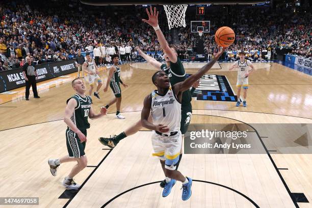 Kam Jones of the Marquette Golden Eagles shoots the ball against Carson Cooper of the Michigan State Spartans during the first half in the second...