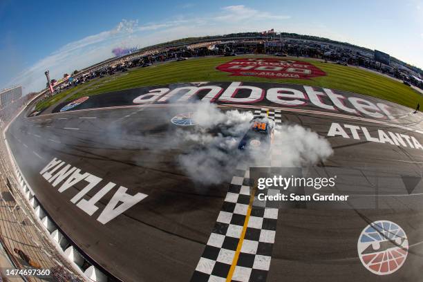 Joey Logano, driver of the Autotrader Ford, celebrates with a burnout after winning during the NASCAR Cup Series Ambetter Health 400 at Atlanta Motor...