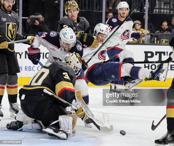 Jiri Patera of the Vegas Golden Knights defends the net against Cole Sillinger and Eric Robinson of the Columbus Blue Jackets in the third period of...