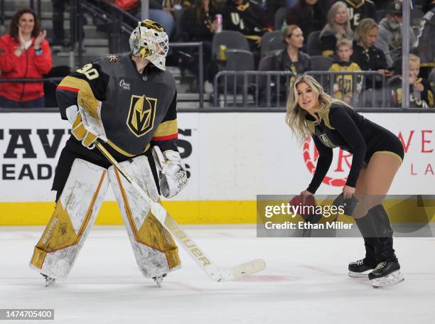 Jiri Patera of the Vegas Golden Knights helps a member of the Knights Guard clean hats off the ice after Jack Eichel of the Golden Knights scored a...