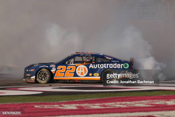 Joey Logano, driver of the Autotrader Ford, celebrates with a burnout after winning during the NASCAR Cup Series Ambetter Health 400 at Atlanta Motor...