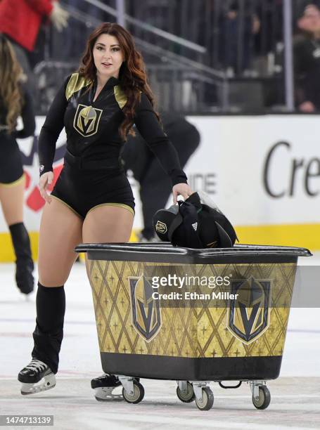 Member of the Knights Guard cleans hats off the ice after Jack Eichel of the Vegas Golden Knights scored a third-period goal, his third goal of the...
