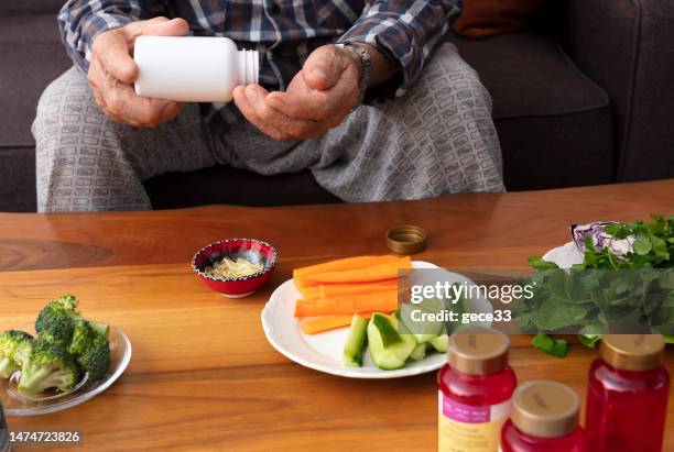 elderly man is getting vitamin pill - vitamin stock pictures, royalty-free photos & images